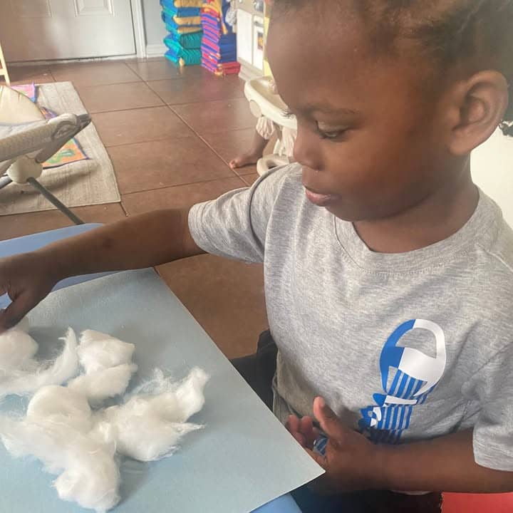A toddler exploring cotton during play